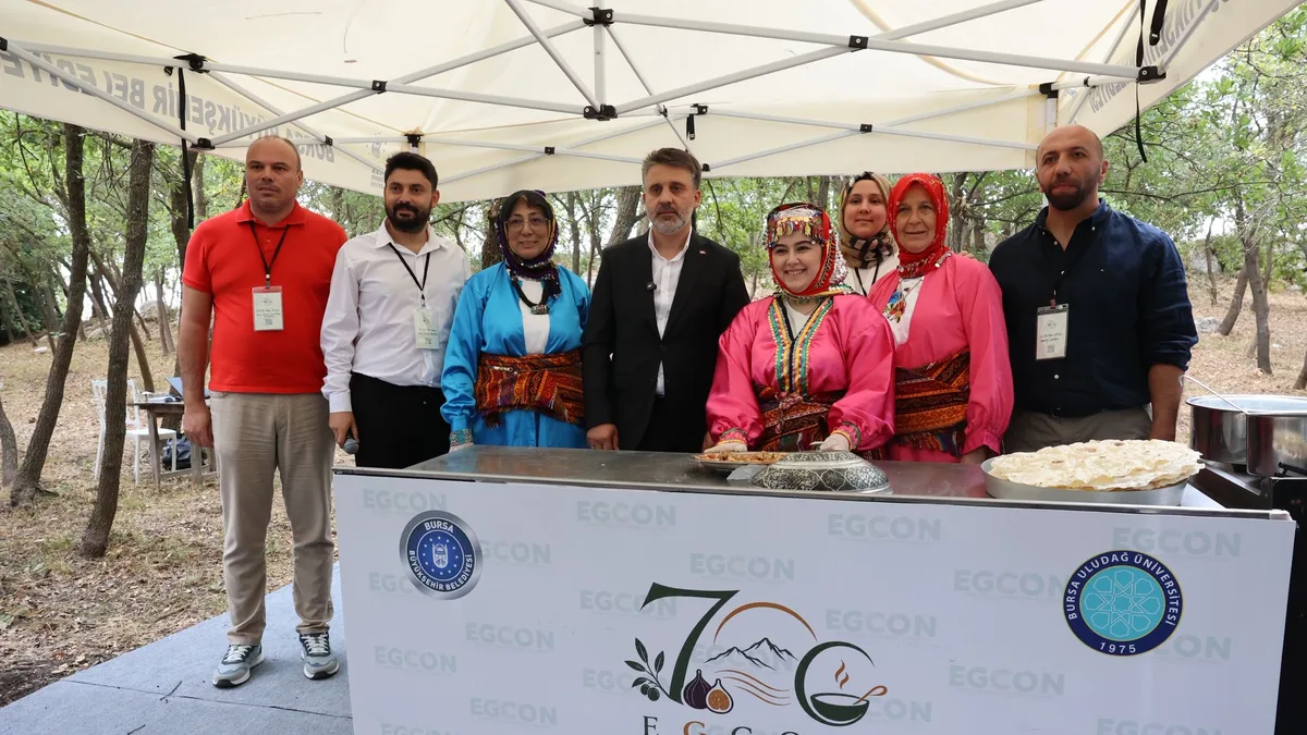 EGCON Bursa 2026 etkinliklerinde geleneksel kıyafetli katılımcılar ve akademisyenler, Bursa’nın yöresel mutfak kültürünü tanıtan gastronomi standında buluştu.