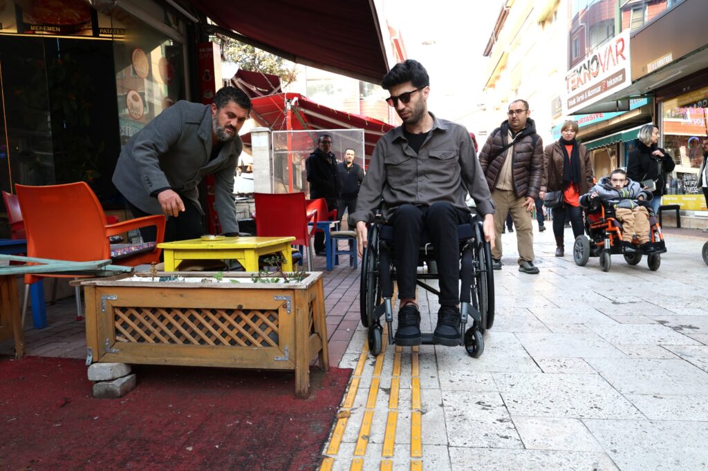 Osmangazide engelli yolunu işgal eden masa ve saksılar nedeniyle tekerlekli sandalyeli bireyin yaşadığı erişim sorunu ve zabıta denetimi